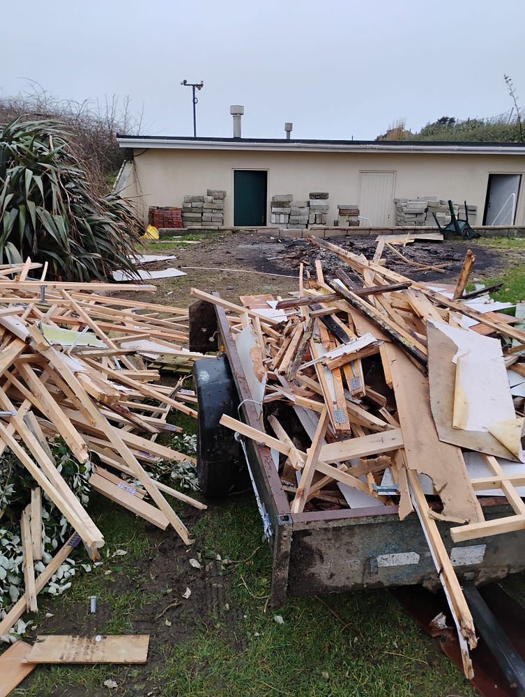 Debris and broken timber piled outside buildings at Seaview Holiday Park